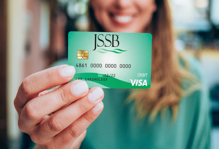 Woman holding JSSB credit card.